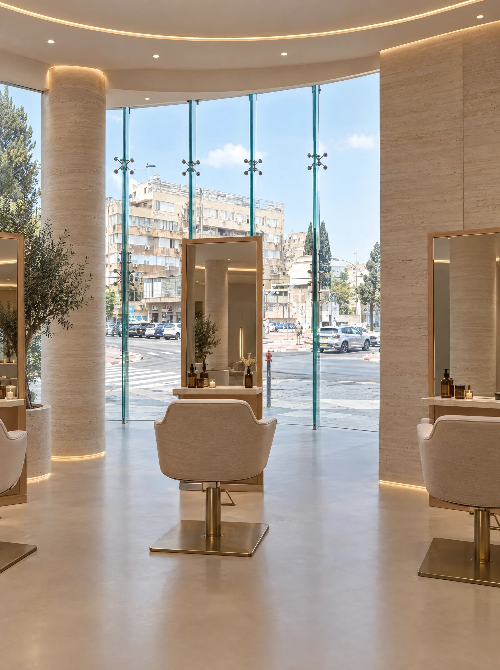 Un poste de coiffure : miroir cerclé de laiton et fauteuil crème, face à la vitrine